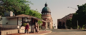 Movie still from “Irrational Man” (2015), directed by Woody Allen – People are walking on the sidewalk near a building; Extreme Wide shot, Low angle