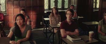 Movie still from “Irrational Man” (2015), directed by Woody Allen – A group of people sitting at a table in a room; Medium shot, Over the shoulder angle