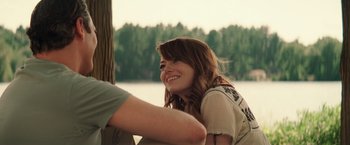 Movie still from “Irrational Man” (2015), directed by Woody Allen – A woman sitting next to a man in front of a tree; Medium shot, Over the shoulder angle