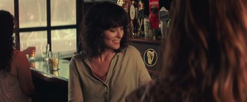 Movie still from “Irrational Man” (2015), directed by Woody Allen – A woman sitting in front of a bunch of beers; Close Up shot, Over the shoulder angle