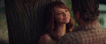 Movie still from “Irrational Man” (2015), directed by Woody Allen – A person sitting next to a tree; Close Up shot, Over the shoulder angle