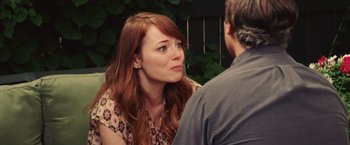 Movie still from “Irrational Man” (2015), directed by Woody Allen – A woman sitting in front of a man in front of bushes; Close Up shot, Over the shoulder angle