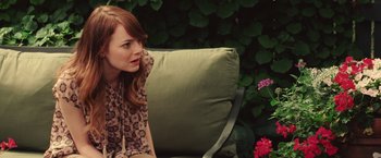 Movie still from “Irrational Man” (2015), directed by Woody Allen – A woman sitting on top of a green couch; Medium shot, Over the shoulder angle