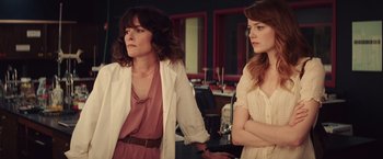 Movie still from “Irrational Man” (2015), directed by Woody Allen – Two women standing next to each other in front of a mirror; Medium shot, Over the shoulder angle