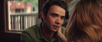 Movie still from “Irrational Man” (2015), directed by Woody Allen – A young man sitting in front of a woman with his hand under his chin; Close Up shot, Over the shoulder angle