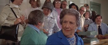 Movie still from “Jaws” (1975), directed by Steven Spielberg – An older woman is looking at a group of older people; Close Up shot, Over the shoulder angle