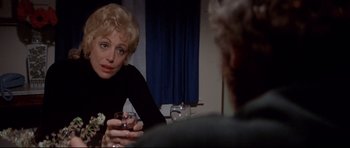 Movie still from “Jaws” (1975), directed by Steven Spielberg – A woman sitting at a table with a glass of wine in front of a man; Close Up shot, Over the shoulder angle