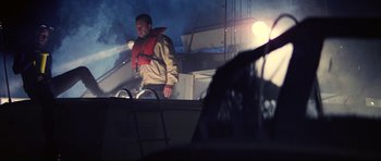 Movie still from “Jaws” (1975), directed by Steven Spielberg – A man standing on top of a boat at night; Medium shot, Low angle