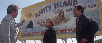 Movie still from “Jaws” (1975), directed by Steven Spielberg – A man standing in front of an advertisement; Medium shot, Low angle