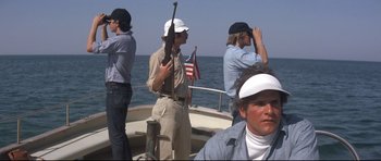 Movie still from “Jaws” (1975), directed by Steven Spielberg – A group of men standing on a boat in the water; Medium shot, Low angle