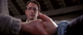 Movie still from “Jaws” (1975), directed by Steven Spielberg – A person wearing glasses pointing at something; Close Up shot, Low angle