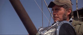 Movie still from “Jaws” (1975), directed by Steven Spielberg – A person wearing a hat on a boat; Close Up shot, Low angle