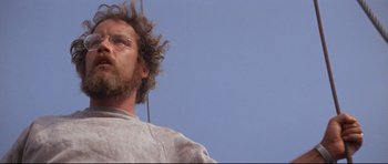 Movie still from “Jaws” (1975), directed by Steven Spielberg – A person with a beard and glasses; Close Up shot, Low angle