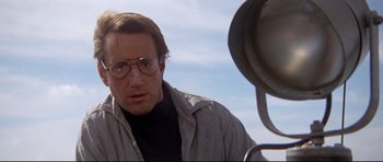 Movie still from “Jaws” (1975), directed by Steven Spielberg – A person wearing glasses and a jacket; Close Up shot, Low angle
