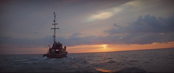 Movie still from “Jaws” (1975), directed by Steven Spielberg – A boat sailing in the ocean at sunset; Extreme Wide shot, Low angle