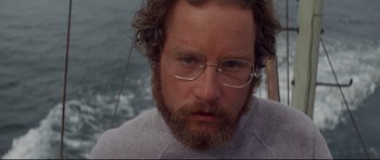 Movie still from “Jaws” (1975), directed by Steven Spielberg – A person with a beard wearing glasses; Close Up shot, Low angle
