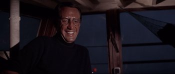 Movie still from “Jaws” (1975), directed by Steven Spielberg – A man wearing glasses and a black sweater; Close Up shot, Over the shoulder angle
