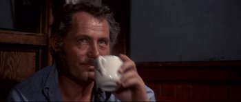Movie still from “Jaws” (1975), directed by Steven Spielberg – A person drinking a cup of coffee; Close Up shot, Low angle