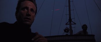 Movie still from “Jaws” (1975), directed by Steven Spielberg – A man standing in front of a building at night; Close Up shot, Low angle