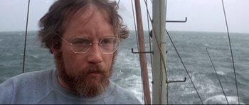 Movie still from “Jaws” (1975), directed by Steven Spielberg – A person with a beard wearing glasses; Close Up shot, Low angle