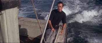 Movie still from “Jaws” (1975), directed by Steven Spielberg – A man standing on the side of a boat in the water; Medium shot, Low angle