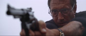 Movie still from “Jaws” (1975), directed by Steven Spielberg – A man with glasses is holding a gun; Close Up shot, Low angle