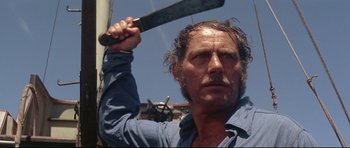 Movie still from “Jaws” (1975), directed by Steven Spielberg – A person holding a knife over their head; Close Up shot, Low angle