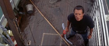 Movie still from “Jaws” (1975), directed by Steven Spielberg – A man is holding a hose while standing on the floor; Medium shot, Overhead angle