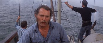 Movie still from “Jaws” (1975), directed by Steven Spielberg – A man on a sailboat in the water; Medium shot, Low angle