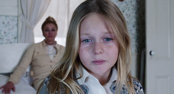 Movie still from “Joy” (2015), directed by David O. Russell – A little girl with blue eyes looking at the camera; Close Up shot, Over the shoulder angle