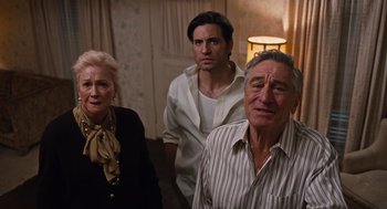 Movie still from “Joy” (2015), directed by David O. Russell – A group of people standing next to each other in a room; Medium shot, High angle