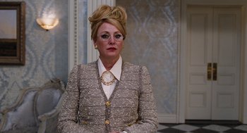 Movie still from “Joy” (2015), directed by David O. Russell – A woman in a silver suit and white shirt; Medium shot, Over the shoulder angle