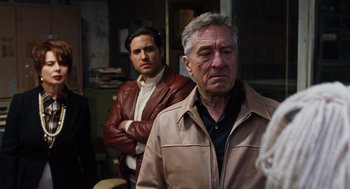 Movie still from “Joy” (2015), directed by David O. Russell – Two men standing next to each other in a room; Medium shot, Over the shoulder angle
