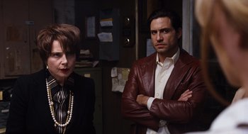 Movie still from “Joy” (2015), directed by David O. Russell – A man and a woman standing next to each other in a room; Medium shot, Over the shoulder angle