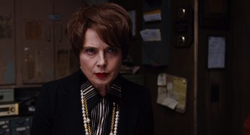 Movie still from “Joy” (2015), directed by David O. Russell – A woman in a black jacket and a striped shirt; Close Up shot, Over the shoulder angle