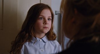 Movie still from “Joy” (2015), directed by David O. Russell – A young girl looking at the camera in front of a mirror; Close Up shot, Over the shoulder angle