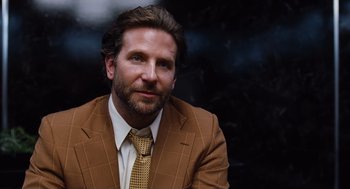 Movie still from “Joy” (2015), directed by David O. Russell – A person wearing a suit and tie; Close Up shot, Over the shoulder angle