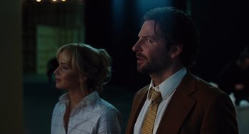 Movie still from “Joy” (2015), directed by David O. Russell – A man and a woman standing next to each other; Close Up shot, Low angle
