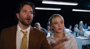 Movie still from “Joy” (2015), directed by David O. Russell – A man and a woman standing next to each other; Close Up shot, Over the shoulder angle