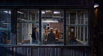 Movie still from “Joy” (2015), directed by David O. Russell – A group of people standing in front of a store window; Wide shot, Over the shoulder angle