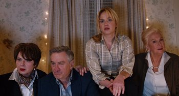 Movie still from “Joy” (2015), directed by David O. Russell – A man and a woman sitting next to each other on a couch; Medium shot, High angle