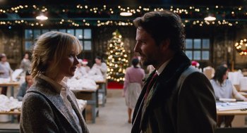 Movie still from “Joy” (2015), directed by David O. Russell – A man and a woman standing next to each other in front of a christmas tree; Medium shot, Over the shoulder angle