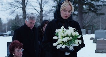 Movie still from “Joy” (2015), directed by David O. Russell – A woman holding a bouquet of white flowers; Medium shot, Over the shoulder angle