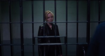 Movie still from “Joy” (2015), directed by David O. Russell – A woman standing behind bars in front of a wall; Medium shot, Low angle