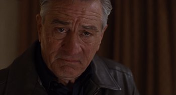 Movie still from “Joy” (2015), directed by David O. Russell – An older man wearing a black shirt and a leather jacket; Close Up shot, Low angle