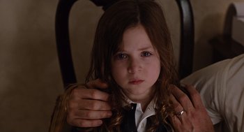 Movie still from “Joy” (2015), directed by David O. Russell – A little girl is holding her hair in her hands; Close Up shot, Over the shoulder angle