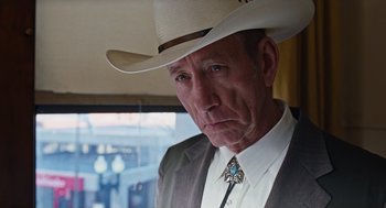 Movie still from “Joy” (2015), directed by David O. Russell – A person wearing a cowboy hat; Close Up shot, Over the shoulder angle