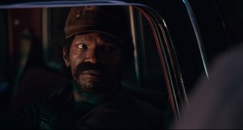 Movie still from “Just Mercy” (2019), directed by Destin Daniel Cretton – A man with a hat sitting in the back of a car; Close Up shot, Over the shoulder angle