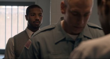 Movie still from “Just Mercy” (2019), directed by Destin Daniel Cretton – A man in a suit standing next to another man in a uniform; Close Up shot, Over the shoulder angle