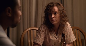 Movie still from “Just Mercy” (2019), directed by Destin Daniel Cretton – A woman sitting at a table with a bottle; Close Up shot, Over the shoulder angle